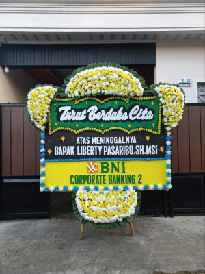 Papan Bunga Duka di Kepala Madan