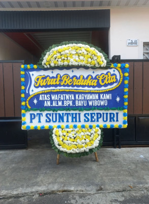 Papan Bunga Duka di Kepala Madan