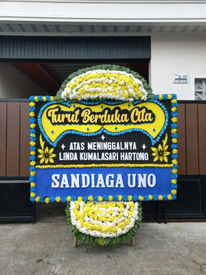 Papan Bunga Duka di Kepala Madan