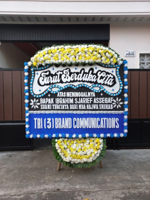 Papan Bunga Duka di Kepala Madan